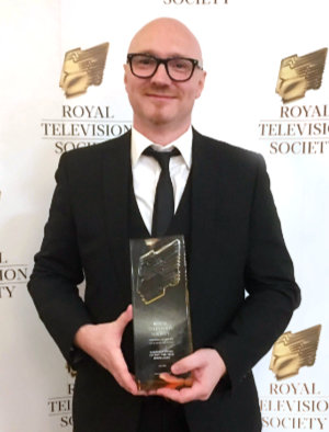 Andrew Griffiths holding award from the Royal Television Society